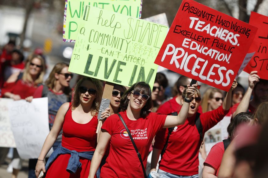 Teachers march during a rally, Friday, April 27, 2018, in Denver. More than 10,000 teachers from more than 20 districts scattered across Colorado are demonstrating as part of a burgeoning teacher uprising from the East to the interior West that is demanding more tax dollars be spent in public schools. (AP Photo/David Zalubowski)