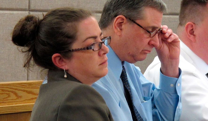 Mark Desimone, right, removes his glasses during opening arguments in his trial on Friday, April 27, 2018, in Juneau, Alaska, as his attorney, Deborah Macaulay, left, listens. Desimone, a former Arizona legislator, is charged in the shooting death of a man during a hunting and fishing trip in southeast Alaska in 2016. (AP Photo/Becky Bohrer)