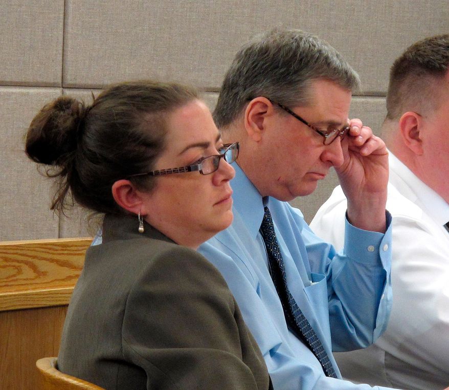 Mark Desimone, right, removes his glasses during opening arguments in his trial on Friday, April 27, 2018, in Juneau, Alaska, as his attorney, Deborah Macaulay, left, listens. Desimone, a former Arizona legislator, is charged in the shooting death of a man during a hunting and fishing trip in southeast Alaska in 2016. (AP Photo/Becky Bohrer)