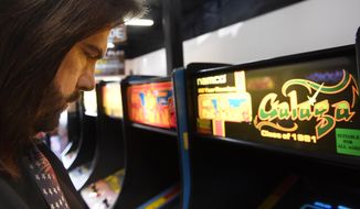 Billy Mitchell, a competitive gamer who lives in Hollywood, Fla.,  plays at Arcade Game Sale in Fort Lauderdale, Fla. (Taimy Alvarez/South Florida Sun-Sentinel via AP)