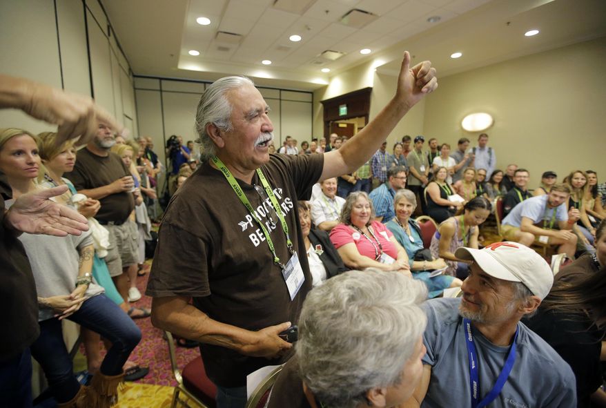 FILE - In this Aug. 4, 2016, file photo, shows Willie Grayeyes, of the Utah Dine Bikeyah raising his hand as he is recognized during a news conference, in Salt Lake City. Navajo Nation leaders are protesting a Utah county's investigation into a Navajo candidate's residency, saying it's an attempt to disqualify a native contender after a federal judge decided voting districts discriminated against Navajos. San Juan County spokeswoman Natalie Callahan countered Friday, April 27, 2018, that the investigation into a citizen complaint questioning whether Democratic candidate Willie Grayeyes lives on the Utah side of the nearby Arizona border isn't related to politics or race. (AP Photo/Rick Bowmer, File)