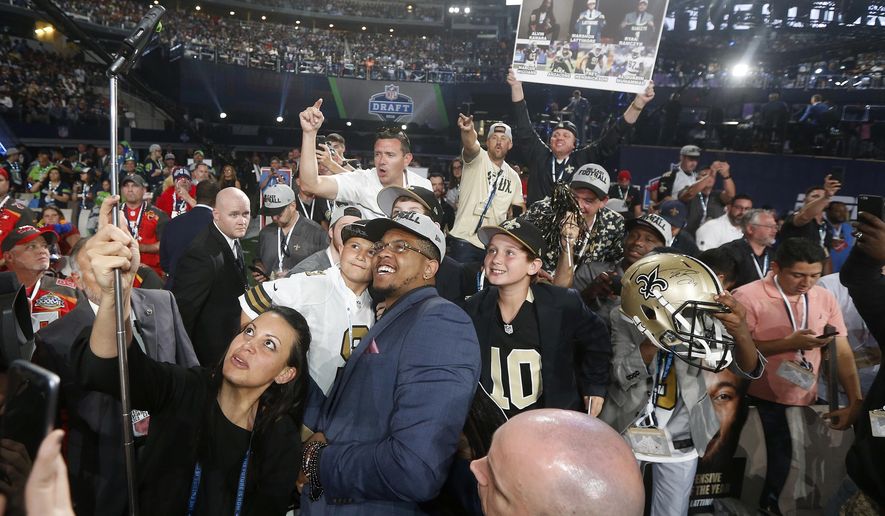 UTSA's Marcus Davenport, center, celebrates by taking a selfie with New Orleans Saints fans after being selected by the team during the first round of the NFL football draft, Thursday, April 26, 2018, in Arlington, Texas. (AP Photo/Michael Ainsworth)