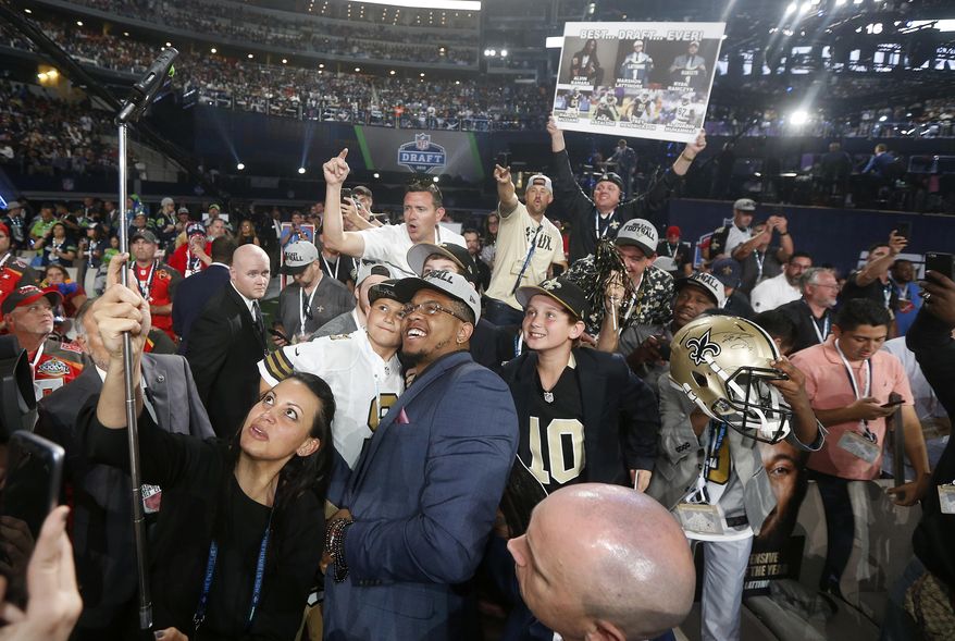 UTSA's Marcus Davenport, center, celebrates by taking a selfie with New Orleans Saints fans after being selected by the team during the first round of the NFL football draft, Thursday, April 26, 2018, in Arlington, Texas. (AP Photo/Michael Ainsworth)