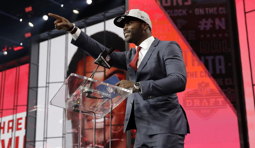Former Atlanta Falcons player Michael Vick gestures to Falcons fans as he announces Colorado&#39;s Isaiah Oliver as the team&#39;s pick during the second round of the NFL football draft Friday, April 27, 2018, in Arlington, Texas. (AP Photo/Eric Gay)