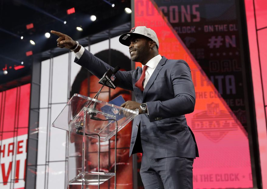 Former Atlanta Falcons player Michael Vick gestures to Falcons fans as he announces Colorado&#39;s Isaiah Oliver as the team&#39;s pick during the second round of the NFL football draft Friday, April 27, 2018, in Arlington, Texas. (AP Photo/Eric Gay)