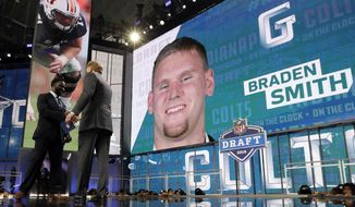 Joseph Addai, left, and NFL Commissioner Roger Goodell, right, announce Auburn&#x27;s Braden Smith as as a selection by the Indianapolis Colts during the second round of the football league&#x27;s draft Friday, April 27, 2018, in Arlington, Texas. (AP Photo/Eric Gay)