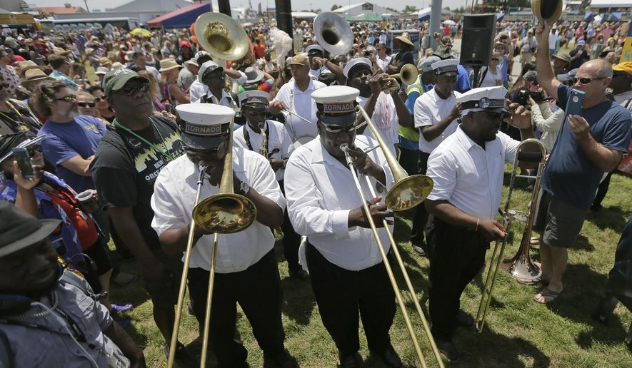 The Tornado Brass Band plays during a jazz funeral to honor Fats Domino makes its way through the crowd at Jazz Fest 2018 in New Orleans on Saturday, April 28, 2018. (Brett Duke/NOLA.com The Times-Picayune via AP)
