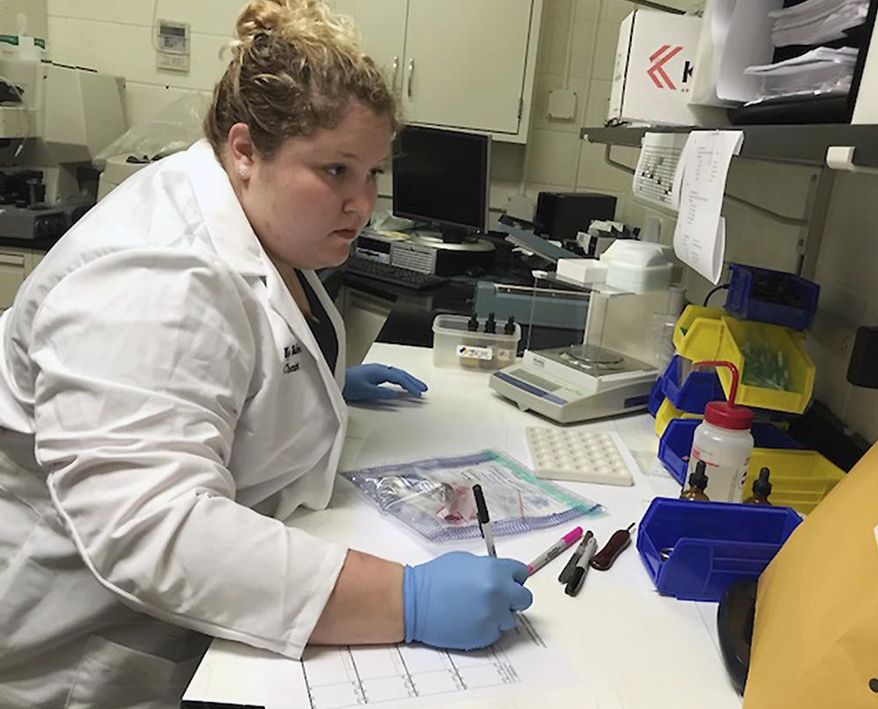 In this Friday, April 13, 2018 photo, Chemist Meg Walker works with evidence in the Lexington County Sherriff's Department's forensics laboratory, in Lexington, S.C. Lexington County deputies stopped field testing in 2017 as a precautionary measure due to dangers associated with synthetic drugs like fentanyl. (AP Photo/Christina Myers)