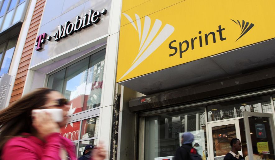 In this April 27, 2010, file photo, a woman using a cell phone walks past T-Mobile and Sprint stores in New York. T-Mobile and Sprint are trying again to combine in a deal that would reshape the U.S. wireless landscape, the companies announced Sunday, April 29, 2018. (AP Photo/Mark Lennihan, File)
