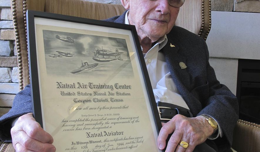 In this Wednesday, April 25, 2018 photo, World War II veteran Bob Barger poses with his Naval flight school certificate in Toledo, Ohio. Barger is set to graduate from the University of Toledo after a review of his transcripts showed he completed enough classes in the late 1940s for a two-year degree. (AP Photo/John Seewer)