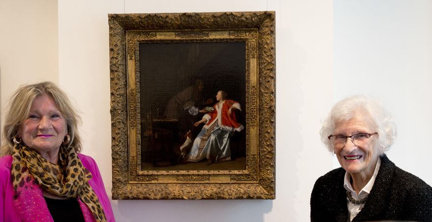 Ninety-seven-year-old Charlotte Bischoff van Heemskerck, right, and her daughter Rudolphine pose next to the painting "The Oyster Meal" by Jacob Ochtervelt (1634-1682), right, at Sotheby's in Amsterdam, Netherlands, Tuesday, May 1, 2018. The Dutch Old Master painting, belonging to Charlotte's father, was looted by the Nazis in the dying days of World War II and is being put up for auction after it was discovered hanging in the official residence of the Lord Mayor of the City of London and returned late last year to its rightful owners. (AP Photo/Peter Dejong)