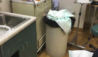This undated photo provided by Christopher Wilson shows cluttered and unsanitary conditions that Wilson, an Army veteran, found in an exam room where he waited to be seen at a Veterans Affairs clinic in Salt Lake City. The VA is investigating why he was put in a room with an overflowing trash can and medical supplies strewn about. Dr. Karen Gribbin, chief of staff at the George E. Wahlen Department of Veteran Affairs Medical Center, apologized on Monday, April 30, 2018. &amp;quot;Mr. Wilson should not have been placed in the room in that condition,&amp;quot; Gribbin said. (Christopher Wilson via AP)