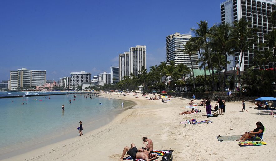 FILE - In this March 13, 2017, file photo, people relax on the beach in Waikiki in Honolulu. Many sunscreen makers could soon be forced to change their formulas or be banned from selling lotions in Hawaii. Hawaii state lawmakers on Tuesday passed a measure that would ban the local sale of sunscreens containing oxybenzone and octinoxate by 2021 in an effort to protect coral reefs.(AP Photo/Caleb Jones, File)