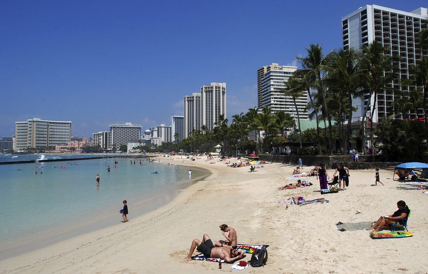 FILE - In this March 13, 2017, file photo, people relax on the beach in Waikiki in Honolulu. Many sunscreen makers could soon be forced to change their formulas or be banned from selling lotions in Hawaii. Hawaii state lawmakers on Tuesday passed a measure that would ban the local sale of sunscreens containing oxybenzone and octinoxate by 2021 in an effort to protect coral reefs.(AP Photo/Caleb Jones, File)