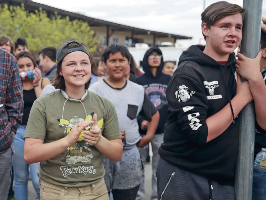 Priya Hasham and Miguel Alvarez applaud while listening to Andreas Sandoval's presentation on the Second Amendment during the local Stand for the 2nd Walkout rally at the Academy for Technology and the Classics on Wednesday May 2, 2018. (Gabriela Campos /Santa Fe New Mexican via AP)