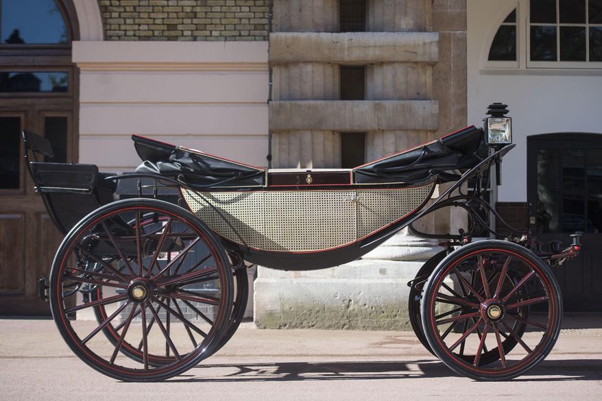 The Ascot Landau open carriage, which will be used in the case of dry weather, for the wedding of Britain's Prince Harry and Meghan Markle, stands ready in the Royal Mews at Buckingham Palace in London, Tuesday May 1, 2018. Prince Harry and Meghan Markle will tie the knot at St. George's Chapel in Windsor, southern England on May 19, with about 600 guests and some 2,600 neighbours, staff and specially selected members of the public greeting the happy couple outside the chapel. The Scottish State Coach will be used in the case of wet weather. (Victoria Jones/Pool via AP)