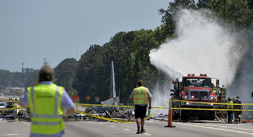 A firetruck sprays foam over the remains of an Air National Guard C-130 cargo plane from Puerto Rico that crashed near the intersection of state highway Georgia 21 and Crossgate Road in Port Wentworth, Ga., Wednesday, May 2, 2018. (Steve Bisson/Savannah Morning News via AP) ** FILE **