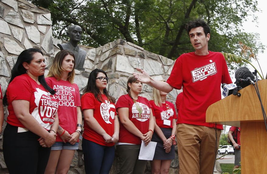 Teacher Noah Karvelis, right, speaks during a news conference prior to protest organizers announcing their intention to go back to work as the statewide teachers strike enters a fourth day at the Arizona Capitol, Tuesday, May 1, 2018, in Phoenix. (AP Photo/Ross D. Franklin)
