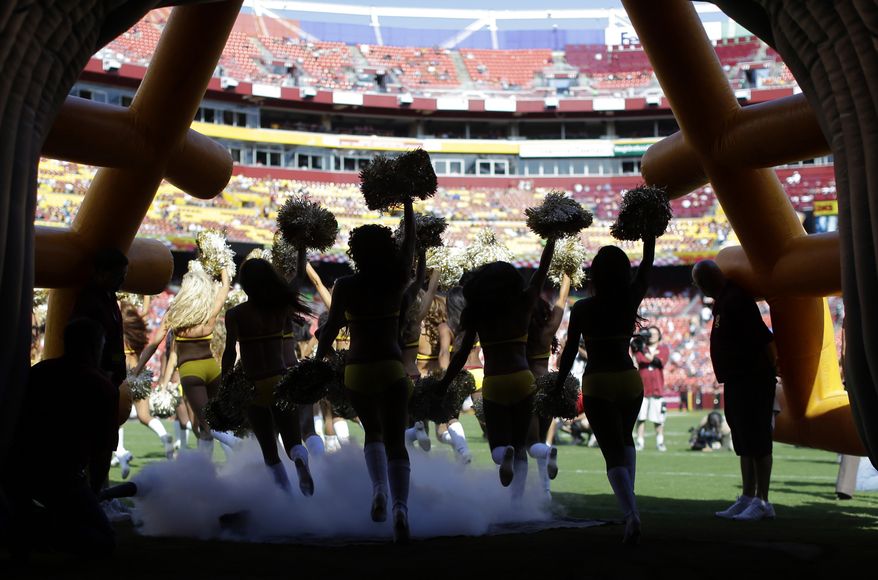 FILE - In this Aug. 24, 2013, file photo, Washington Redskins cheerleaders run out of a tunnel before an NFL preseason football game against the Buffalo Bills in Landover, Md. The Redskins say they're concerned by allegations made by cheerleaders in a New York Times article about a trip to Costa Rica for a photo shoot in 2013. Team president Bruce Allen said in a statement Thursday, May 3, 2018, that the organization is immediately looking into the situation. (AP Photo/Patrick Semansky, File) **FILE**