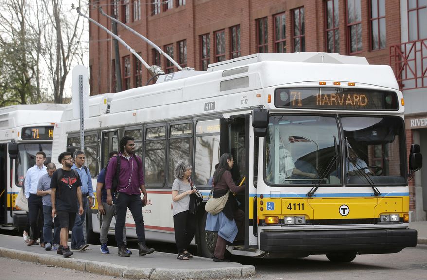 In this Wednesday, May 2, 2018 photo passengers board a bus powered by electricity supplied through overhead wires, in Watertown, Mass. According to a report released by Massachusetts Public Interest Research Group, or MASSPIRG, Thursday, May 3, 2018, cities and states across the U.S. should move toward replacing their old, diesel-fueled bus fleets with battery electric-powered buses as another step toward weaning the country off fossil fuels. A MASSPIRG spokesman said Thursday that buses with overhead electrical wires are great where the infrastructure is set up for them. (AP Photo/Steven Senne)
