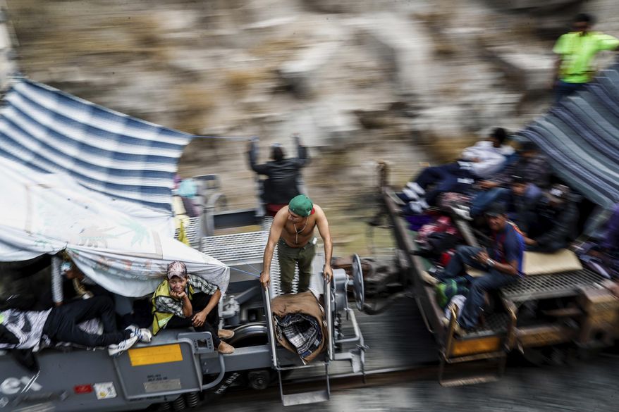 FILE - In this April 21, 2018 file photo, Central American migrants, who attended the annual Migrants Stations of the Cross caravan for migrants' rights, ride a northern-bound train known as "La Bestia," or The Beast, as they arrive to Hermosillo, Sonora state, Mexico. The group that led a monthlong caravan of Central Americans seeking asylum in the United States wanted to draw attention to the plight of people in the violent region. (AP Photo/Luis Gutierrez)