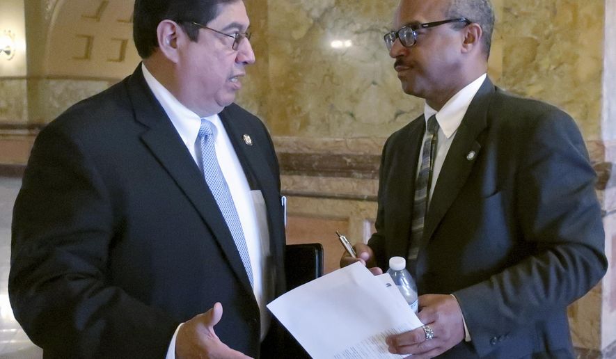 Kansas state Rep. Louis Ruiz, left, and Sen. David Haley, right, both D-Kansas City, confer during a break in negotiations on adoption legislation, Thursday, May 3, 2018, at the Statehouse in Topeka, Kan. The legislation would prevent the state from barring faith-based agencies from providing adoption services if they refuse for religious reasons to place children in LGBT homes. (AP Photo/John Hanna)