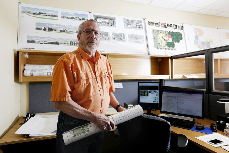 In this Friday, April 27, 2018 photo, John Sisco, an architect with the Blythe Group + Co., works in his office in Grand Junction, Colo. For Sisco and his wife, their move to the Grand Valley was a win on two counts. (Chancey Bush/The Grand Junction Daily Sentinel via AP)