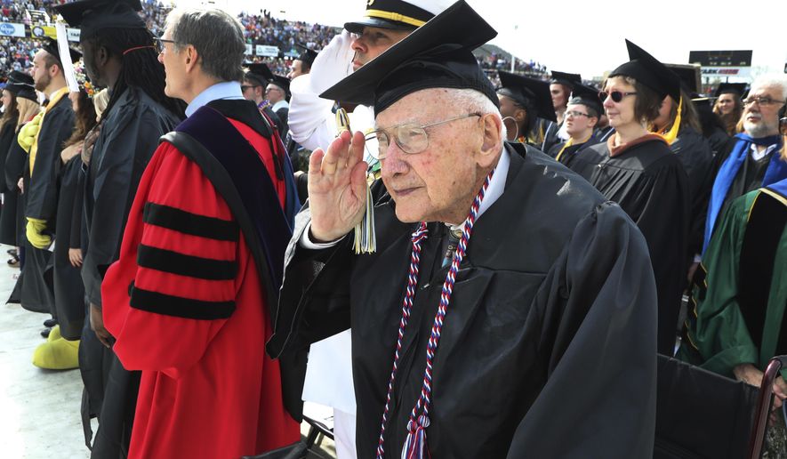 World War II veteran Bob Barger stands during the national anthem at the commencement ceremony at the University of Toledo, Saturday, May 5, 2018, in Toledo, Ohio. Now, 68 years since he last sat in a classroom, Barger graduated after a review of his transcripts from the late 1940s showed he completed enough courses to qualify for an associate's degree — a two-year diploma not offered when he was still in school. "It was something I never dreamed of," the 96-year-old Barger said. "I knew I couldn't go back to school now. The university took a look at Barger's old school records because of a friendship he struck up with Haraz Ghanbari, the school's director of military and veteran affairs. (AP Photo/Carlos Osorio)
