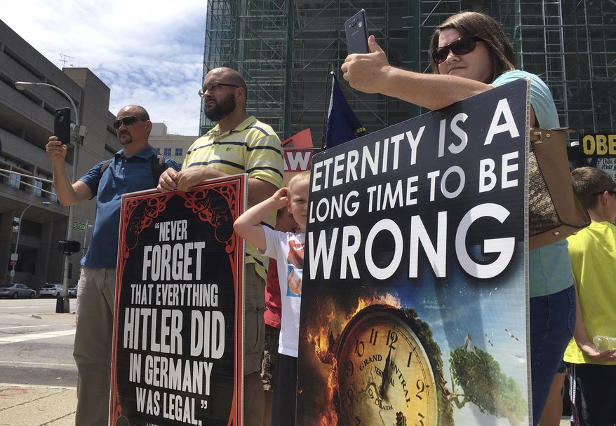 FILE - In this Wednesday, July 19, 2017 file photo, abortion opponents with the group Operation Save America gather during a rally in downtown Louisville, Ky. On July 21, 2017, a federal judge established a buffer zone outside the EMW Women's Surgical Center in Louisville to keep anti-abortion protesters from assembling in front of the entrance, after at least 10 protesters were arrested for blocking it earlier in the month. (AP Photo/Dylan Lovan)