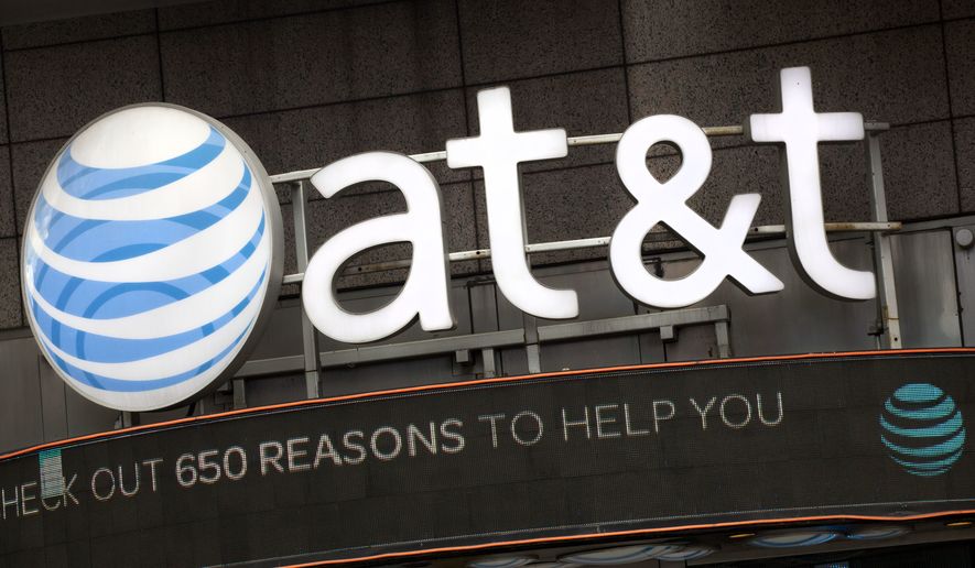 FILE - In this Monday, Oct. 24, 2016, file photo, the AT&T logo is positioned above one of its retail stores, in New York. AT&T Inc. reports earnings Tuesday, April 25, 2017. (AP Photo/Mark Lennihan, File)