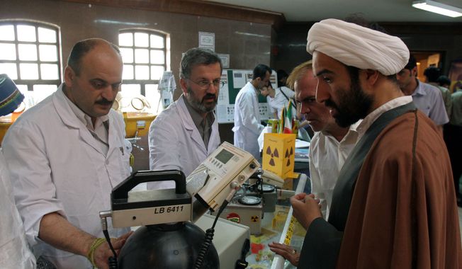 In this May 2, 2006, file photo, Iranian technicians explain a piece of equipment to a clergyman during an exhibition of Iran&#x27;s Atomic Energy Organization at the Qom University in Qom, Iran. Iran&#x27;s nuclear deal with world powers faces its biggest diplomatic challenge yet as President Donald Trump appears poised to withdraw the U.S. from the accord. (AP Photo/Vahid Salemi, File)