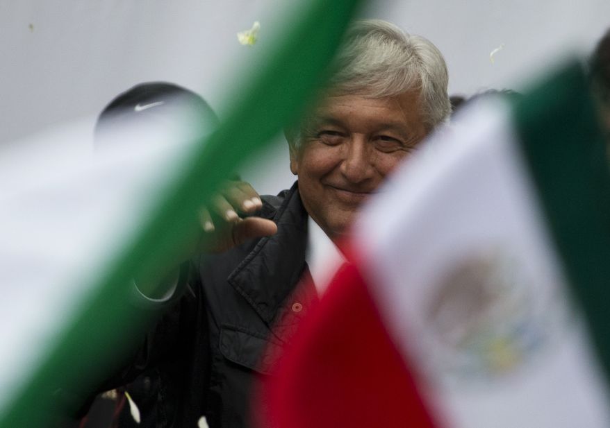 Presidential candidate Andres Manuel Lopez Obrador of the MORENA party waves as supporters hold up Mexican flags, during a campaign rally in the Benito Juarez district of Mexico City, Monday, May 7, 2018. Mexico will choose a new president in general elections on July 1. (AP Photo/Rebecca Blackwell)
