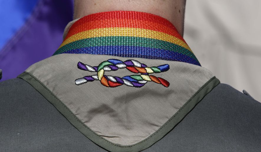 In this June 8, 2014, photo, a Boy Scout wears his kerchief embroidered with a rainbow knot during Salt Lake City&#39;s annual gay pride parade. An announcement Tuesday night, May 8, 2018, by The Church of Jesus Christ of Latter-day Saints and Boy Scouts will mark an end to close relationship that lasted more than a century built on their shared values. The religion will move its remaining boys into its own scouting-type program. (AP Photo/Rick Bowmer, File)