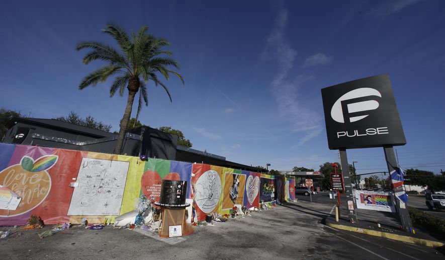 In this Nov. 30, 2016, file photo, artwork and signatures cover a fence around the Pulse nightclub, scene of a mass shooting, in Orlando, Fla. An interim memorial for the 49 people killed at the nightclub is opening to the public on Tuesday, May 8, 2018. The onePULSE Foundation said that the temporary memorial will open at 3 p.m., at the site of Pulse nightclub, which has remained closed since the June 2016 shooting. (AP Photo/John Raoux, File)