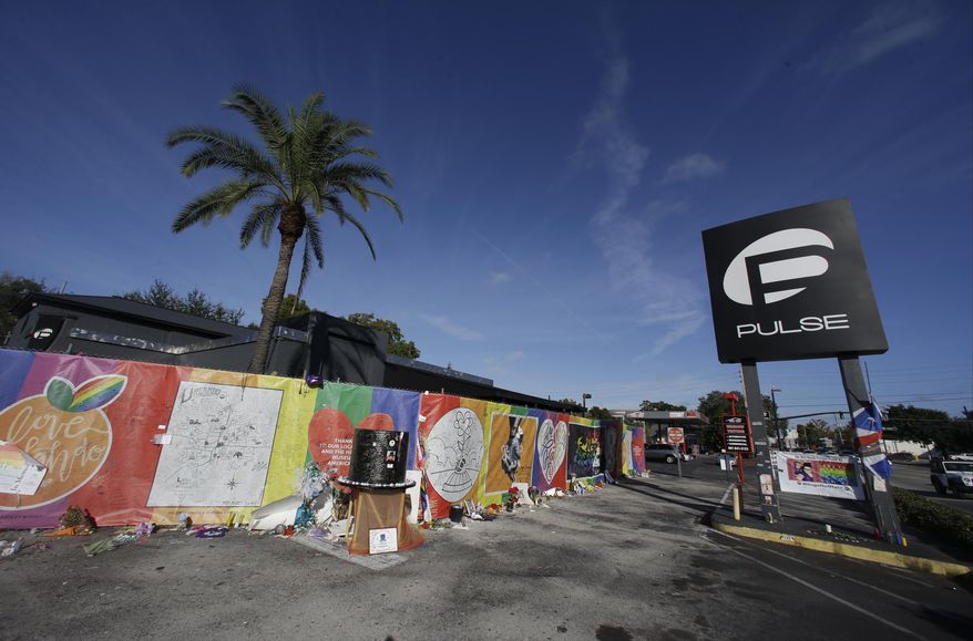 In this Nov. 30, 2016, file photo, artwork and signatures cover a fence around the Pulse nightclub, scene of a mass shooting, in Orlando, Fla. An interim memorial for the 49 people killed at the nightclub is opening to the public on Tuesday, May 8, 2018. The onePULSE Foundation said that the temporary memorial will open at 3 p.m., at the site of Pulse nightclub, which has remained closed since the June 2016 shooting. (AP Photo/John Raoux, File)