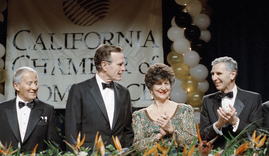FILE - In this March 1, 1990 file photo, President George H. Bush receives a round of applause from California Governor George Deukmejian and his wife, Gloria, as Bush was introduced before the California Chamber of Commerce centennial dinner in Los Angeles. A former chief of staff says two-term California governor Deukmejian, whose anti-spending credo earned him the nickname "The Iron Duke," has died at age 89. Steve Merksamer says Deukmejian died Tuesday, May 8, 2018, of natural causes. (AP Photo/Barry Thumma, File)
