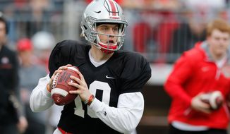 FILE - In this April 14, 2018, file photo, Ohio State quarterback Joe Burrow drops back to pass during an NCAA college spring football game in Columbus, Ohio. Facing the possibility of sitting as a backup for a third season at Ohio State, quarterback Joe Burrow announced on Tuesday, May 8, 2018,  his intention to transfer. The news from the redshirt junior, delivered via Twitter, wasn’t unexpected.  (AP Photo/Jay LaPrete, File)