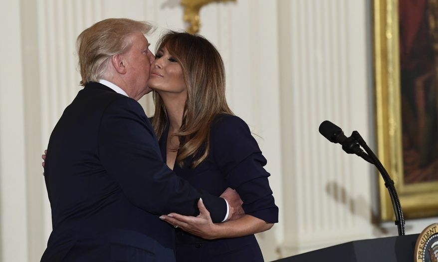President Donald Trump kisses first lady Melania Trump during a celebration of military mothers and spouses event in the East Room of the White House in Washington, Wednesday, May 9, 2018. (AP Photo/Susan Walsh)