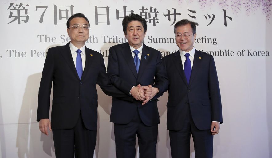 Chinese Premier Li Keqiang, left, Japanese Prime Minister Shinzo Abe, center, and South Korean President Moon Jae-in, right, pose for photographers prior to their summit in Tokyo Wednesday, May 9, 2018. The summit is expected to focus on North Korea's nuclear program and on improving the sometimes-frayed ties among the three northeast Asian neighbors. (AP Photo/Eugene Hoshiko, Pool)