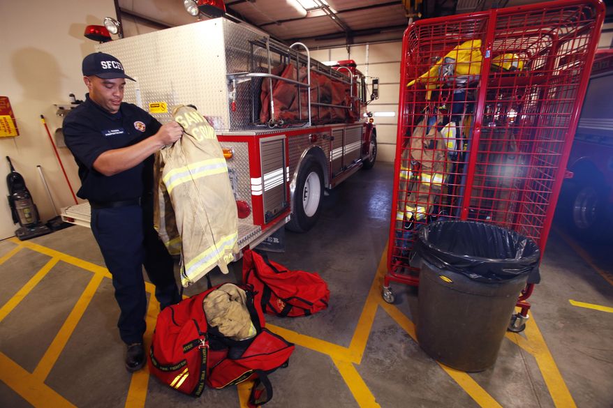 In an April 25, 2018 photo, Lemar Rogers, firefighter at Agua Fria Fire and Rescue station, organizes his fire gear at the station in Santa Fe. Firefighters normally wash their gear after every fire to minimize their exposure to carcinogens but in Santa Fe County firefighters only have one set making them more likely to be exposed to carcinogens because they can only wash their gear after their shift.(Luis Sánchez Saturno/Santa Fe New Mexican via AP)