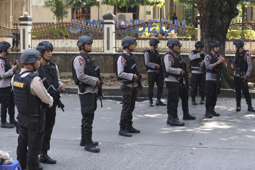 Indonesian Police officers man a roadblock outside the headquarters of elite police force Mobile Brigade, following a prison riot inside the compound in Depok, West Java, Wednesday, May 9, 2018. A riot injured prisoners and some officers at a the police detention center south of Indonesia's capital, police said Wednesday. (AP Photo/Dita Alangkara)