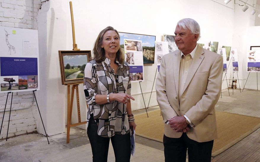 In this May 1 photo, Creative Waco executive direct Fiona Bond, left, and Waco businessman Clifton Robinson talk to supports on the expansion of the Cameron Park Sculpture Zoo which will feature 27 animal sculptures in Waco, Texas. The expanded plan now imagines animal sculptures not only around the approaches to the Waco zoo, but extending along University Parks Drive from Cameron Park to just outside the Vietnam Veterans Memorial at University Parks and Washington Avenue. (Rod Aydelotte/Waco Tribune Herald, via AP)