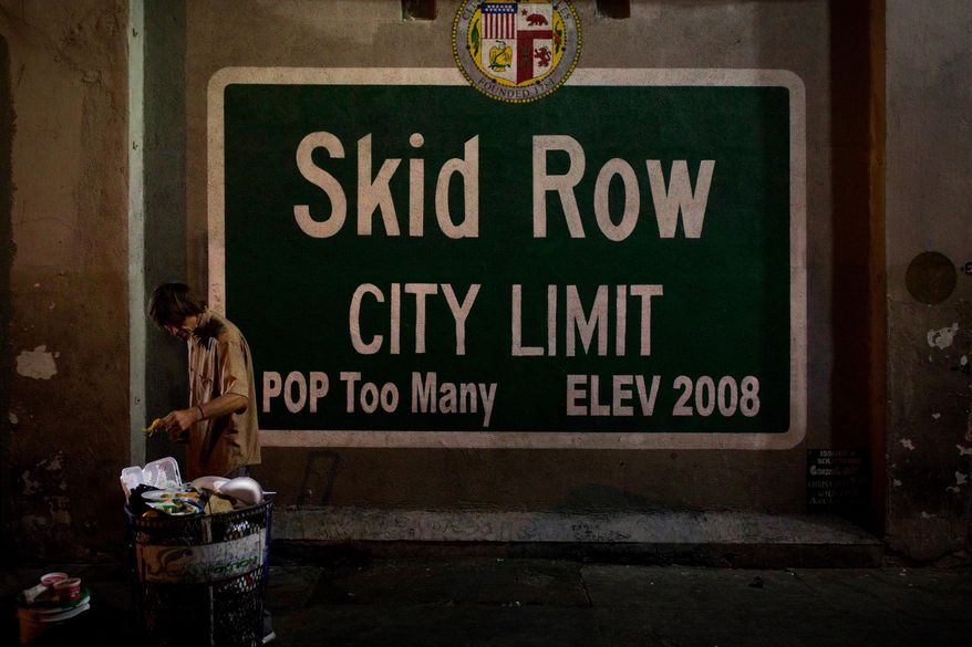 FILE - In this Oct. 28, 2017, file photo, a homeless man takes food from a trash can in Los Angeles' Skid Row area, home to the nation's largest concentration of homeless people in Los Angeles. Thousands of homeless people sleep on the streets of Los Angeles County while many shelter beds go empty. Southern California Public Radio station KPCC reports problems ranging from bedbugs and rats to harassment and lax medical care can make shelters unpalatable.(AP Photo/Jae C. Hong, File)