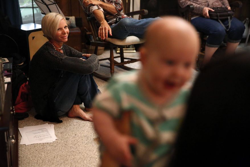FILE - In this May 22, 2016 file photo, Denise Wilkes, left, looks at baby Noah Burton, sitting on a fellow worshiper's lap, during a church service in Birmingham, Ala. Emma and Liam were the most frequently chosen baby names for 2017. For the fourth year in a row, Emma was the top girl's name according to the annual list of the most popular baby names released by the Social Security Administration on Friday, May 11, 2018. Liam pushed last year's champ, Noah, to second to claim the top spot. (AP Photo/Brynn Anderson, File)