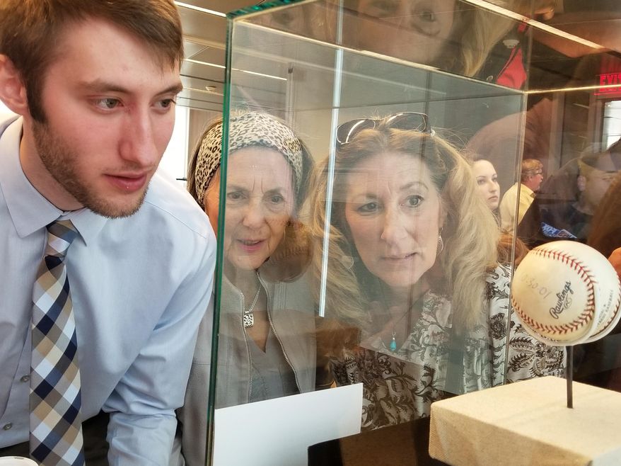In this undated photo, Caden Meier, a junior history major from Canonsburg, views former President George W. Bush's baseball with his grandmother, Adeline Edwards, center, and mother Pamela Jones at the Flight 93 National Memorial near Shanksville, Pa. The exhibit at the memorial's learning center walks visitors through the days after the terrorist attacks that killed 2,977 people, including 40 passengers and crew members on United Flight 93 that crashed in an abandoned strip mine in Somerset County. (Mike Jones/Observer-Reporter via AP)