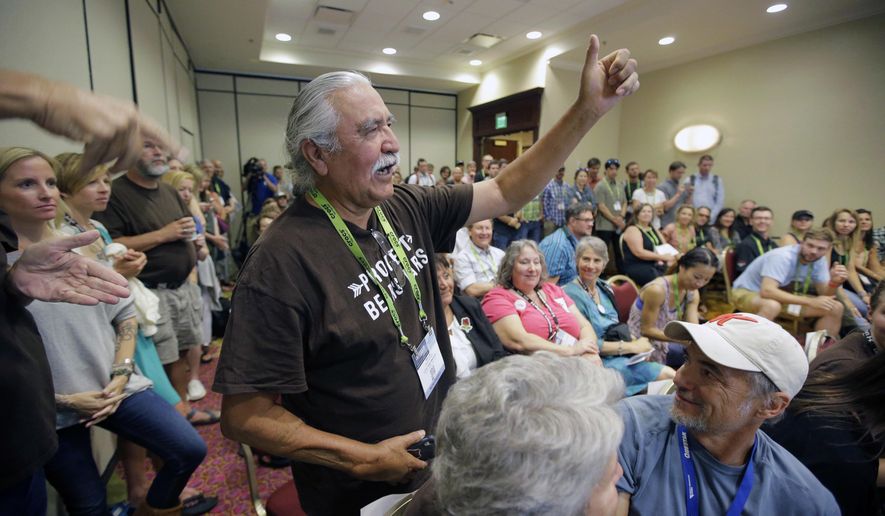 FILE - This Aug. 4, 2016, file photo, shows Willie Grayeyes raising his hand as he is recognized during a news conference, in Salt Lake City. A Utah county says Grayeyes a Navajo man won't qualify to run in the first election since a judge ruled voting districts were illegally drawn based on race. San Juan County said Friday, May 11, 2018, an investigation showed Grayeyes doesn't live in the district, despite being registered to vote there for decades. (AP Photo/Rick Bowmer, File)