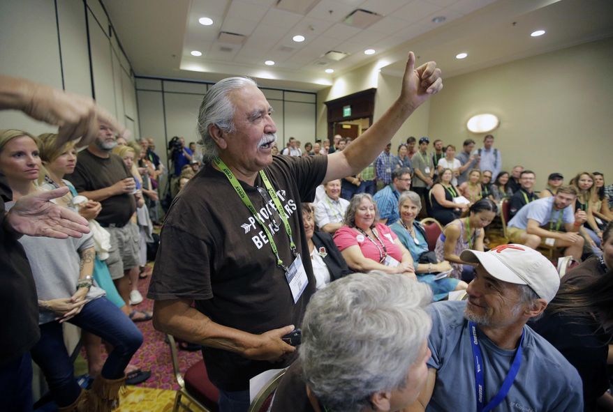 FILE - This Aug. 4, 2016, file photo, shows Willie Grayeyes raising his hand as he is recognized during a news conference, in Salt Lake City. A Utah county says Grayeyes a Navajo man won't qualify to run in the first election since a judge ruled voting districts were illegally drawn based on race. San Juan County said Friday, May 11, 2018, an investigation showed Grayeyes doesn't live in the district, despite being registered to vote there for decades. (AP Photo/Rick Bowmer, File)