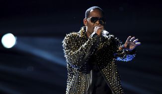 In this June 30, 2013, file photo, R. Kelly performs onstage at the BET Awards at the Nokia Theatre in Los Angeles. Spotify has removed R. Kelly’s music from its playlists, citing its new policy on hate content and hateful conduct. (Photo by Frank Micelotta/Invision/AP, File)