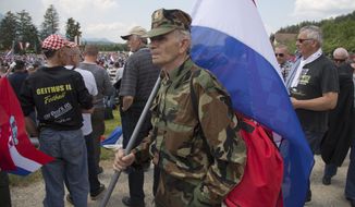 A uniformed man carries a Croatian flag during a commemoration ceremony in Bleiburg, Austria, Saturday, May 12, 2018. Thousands of Croatian far-right supporters have gathered in a field in southern Austria to commemorate the massacre of pro-Nazis by victorious communists at the end of World War II. The controversial annual event was held Saturday amid a surge of far-right sentiments in Croatia, the European Union&#39;s newest member. (AP Photo/Darko Bandic)