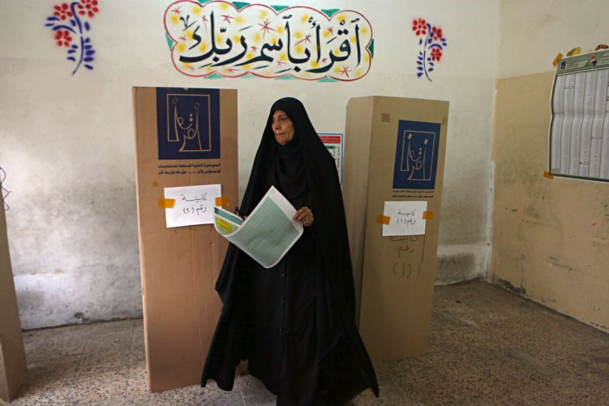 An Iraqi woman prepares to cast her vote in the country&#39;s parliamentary elections in Baghdad, Iraq, Saturday, May 12, 2018. Polls opened across Iraq on Saturday in the first national election since the declaration of victory over the Islamic State group. (AP Photo/Khalid Mohammed)